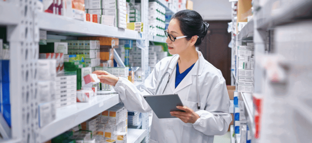 Pharmacist checking inventory on shelves